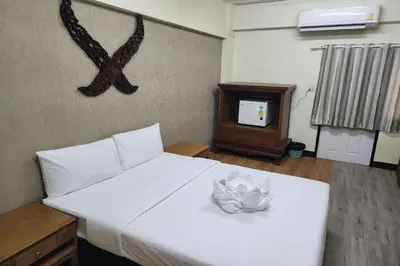 a bedroom with a white bed and a tv at Kim Hotel At Bangplong in Bangkok