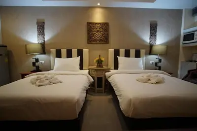 two beds in a hotel room with towels on them at Kim Hotel At Bangplong in Bangkok