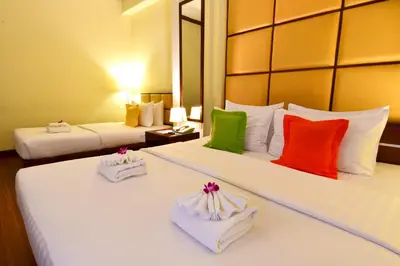 a hotel room with two beds with colorful pillows at Grand Business Inn in Bangkok