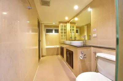 a bathroom with a toilet and a sink and a mirror at Grand Business Inn in Bangkok
