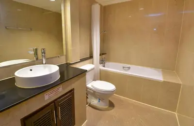 a bathroom with a sink and a toilet and a tub at Grand Business Inn in Bangkok