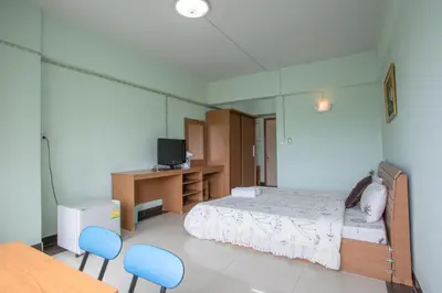 a bedroom with a bed and two blue chairs at The Garden Place Bangkok in Nonthaburi