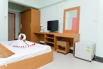 a room with a bed and a vanity and a mirror at The Garden Place Bangkok in Nonthaburi