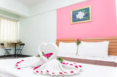 a room with two beds with white towels in the shape of a heart at The Garden Place Bangkok in Nonthaburi