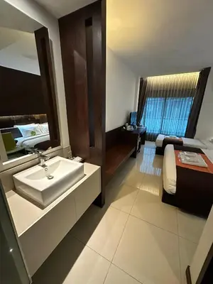 a bathroom with a sink and a bed at Collection O The Bangkok Airport Link Suite in Bangkok