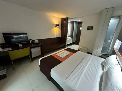a hotel room with a bed and a television at Collection O The Bangkok Airport Link Suite in Bangkok