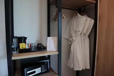 a closet with a white robe hanging on a shelf at Mii Hotel Srinakarin in Bangna