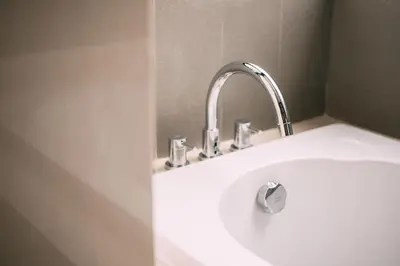 a white sink with a faucet in a bathroom at Mii Hotel Srinakarin in Bangna