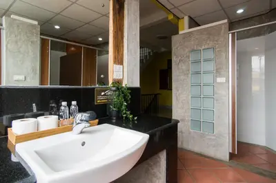 a bathroom with a white sink and a mirror at Banthat Thong Hostel in Bangkok