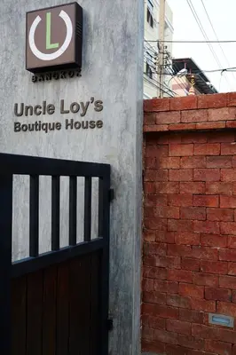 a building with a sign for a louisbourg house at Uncle Loy's Boutique House in Bangkok