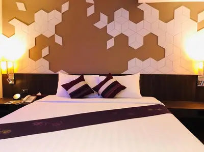 a bedroom with a large bed with two pillows at Paradiso Boutique Suites in Bangkok