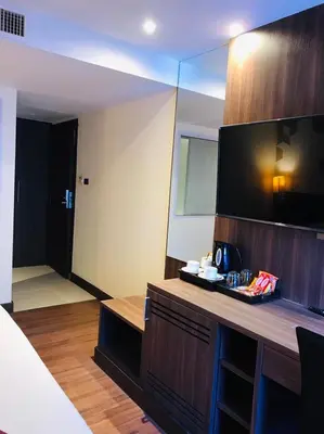 a hotel room with a tv and a counter with a mirror at Paradiso Boutique Suites in Bangkok