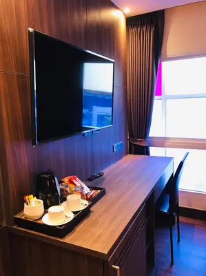 a hotel room with a desk with a flat screen tv at Paradiso Boutique Suites in Bangkok
