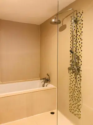 a bathroom with a shower with a tub and a sink at Paradiso Boutique Suites in Bangkok