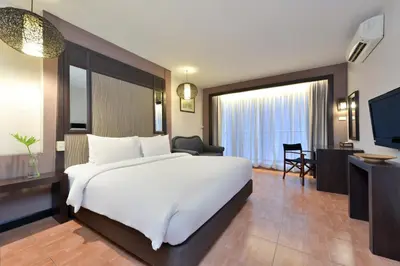 a hotel room with a large white bed and a desk at Royal View Resort - Rang Nam in Bangkok