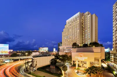 a city with tall buildings and a street with cars at Century Park Hotel in Bangkok