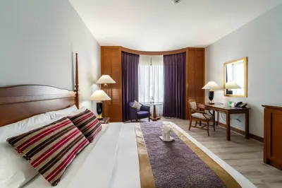 a hotel room with a bed and a desk at Century Park Hotel in Bangkok