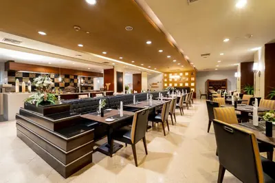 a dining room with long tables and chairs at Century Park Hotel in Bangkok