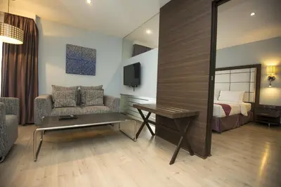 a hotel room with a bed and a desk and a mirror at Sukhumvit Suites Hotel in Bangkok