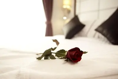 a red rose sitting on top of a bed at Sukhumvit Suites Hotel in Bangkok