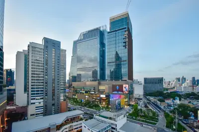 a city skyline with tall buildings and a street at Pinnacle Lumpini Park Hotel in Bangkok