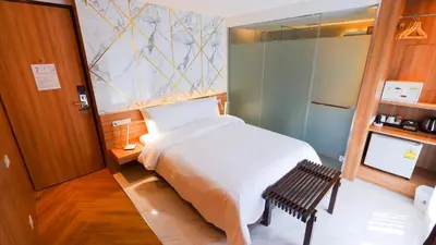 a bedroom with a large white bed and a bench at Pinnacle Dream in Bangkok