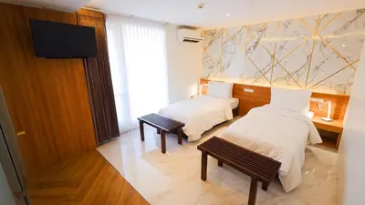 a hotel room with two beds and a flat screen tv at Pinnacle Dream in Bangkok