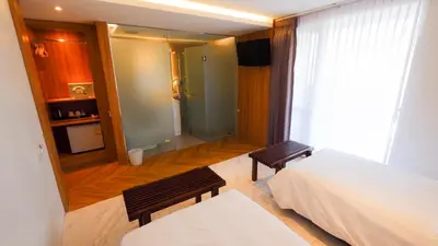 a bedroom with a bed and two benches in front of a window at Pinnacle Dream in Bangkok