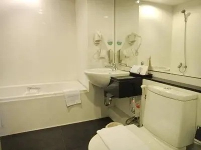 a bathroom with a toilet and a sink and a tub at The Patra Hotel - Rama 9 in Bangkok