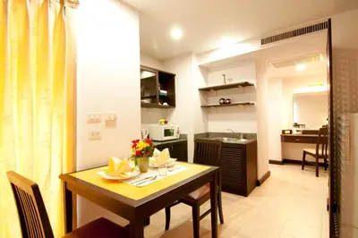 a small kitchen and dining room with a table and chairs at The Patra Hotel - Rama 9 in Bangkok