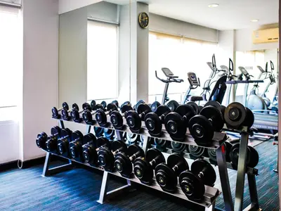 a gym with rows of dumbbells and other exercise equipment at The Patra Hotel - Rama 9 in Bangkok