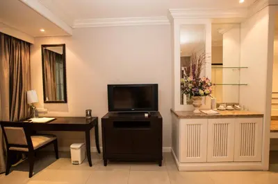 a hotel room with a desk and a tv and a room at Hope Land Hotel 46/1 in Bangkok
