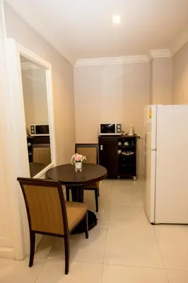 a kitchen with a table and a refrigerator at Hope Land Hotel 46/1 in Bangkok