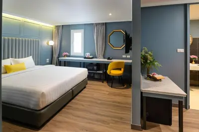 a hotel room with a bed and a desk at The Mulberry Bangkok Khaosan Road in Bangkok