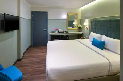 a hotel room with a large bed and a desk at The Mulberry Bangkok Khaosan Road in Bangkok