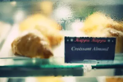 a sign in front of some donuts in a window at Khaosan Palace Hotel in Bangkok