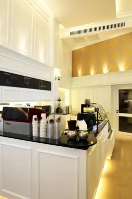 a kitchen with white cabinets and a counter top at Khaosan Palace Hotel in Bangkok