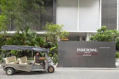 a man sitting in a golf cart in front of a building at PARKROYAL Suites Bangkok in Bangkok