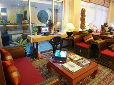 a living room with a couch and a table with a laptop at De Arni Bangkok - SHA Extra Plus in Bangkok