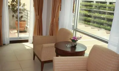 a room with two chairs and a table and windows at De Arni Bangkok - SHA Extra Plus in Bangkok
