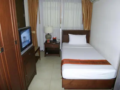 a small bedroom with a bed and a television at De Arni Bangkok - SHA Extra Plus in Bangkok