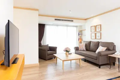 a living room with a couch and a tv at Riverfront Bangkok in Bangkok