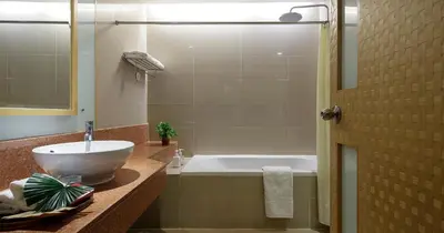 a bathroom with a sink and a bath tub at Grand Richmond Stylish Convention Hotel in Nonthaburi