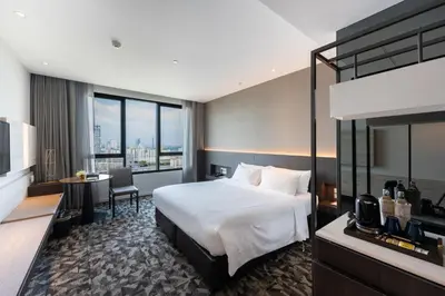 a hotel room with a bed and a desk at Grand Richmond Stylish Convention Hotel in Nonthaburi