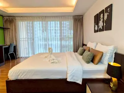 a bedroom with a large white bed with a window at Olive Hotel & Residence Bangkok Sukhumvit 101 near True Digital Park in Bangkok