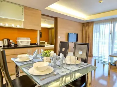 a dining room with a table and a kitchen at Olive Hotel & Residence Bangkok Sukhumvit 101 near True Digital Park in Bangkok