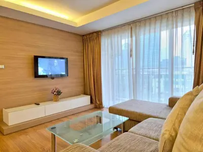 a living room with a couch and a tv at Olive Hotel & Residence Bangkok Sukhumvit 101 near True Digital Park in Bangkok