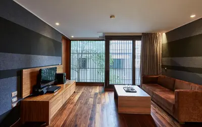 a living room with a couch and a television at LUXX Langsuan Hotel - SHA Plus in Bangkok