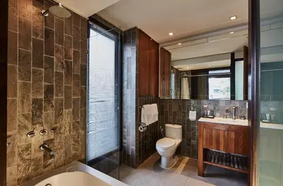a bathroom with a toilet and a sink and a tub at LUXX Langsuan Hotel - SHA Plus in Bangkok