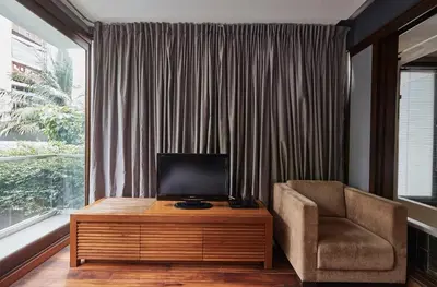 a living room with a chair and a television on a table at LUXX Langsuan Hotel - SHA Plus in Bangkok